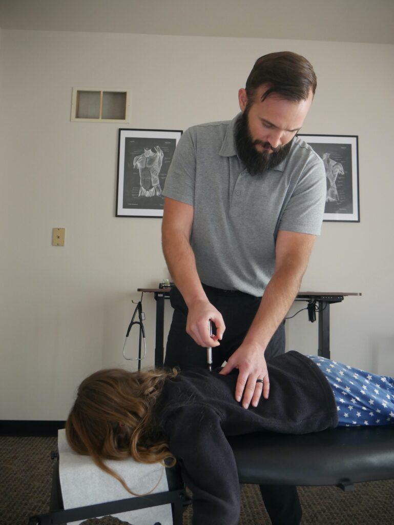 chiropractor using the activator on child